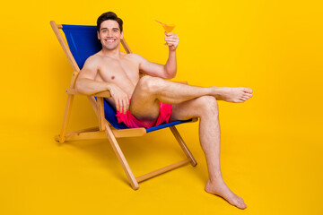 Canvas Print - Full size profile side photo of young man happy smile sit chair enjoy cocktail vacation isolated over yellow color background