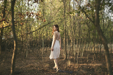 Wall Mural - pretty woman in white dress walks in the forest nature rest