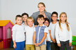 © JackF - Portrait of cheerful positive smiling female teacher with her happy schoolkids in classrom