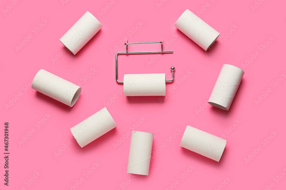 Holder with toilet paper tubes on pink background