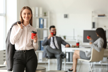 Canvas Print - Young woman having coffee break in office