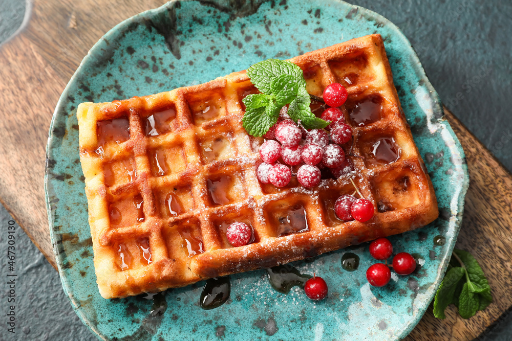 Plate of tasty Belgian Waffles with red currant on black background