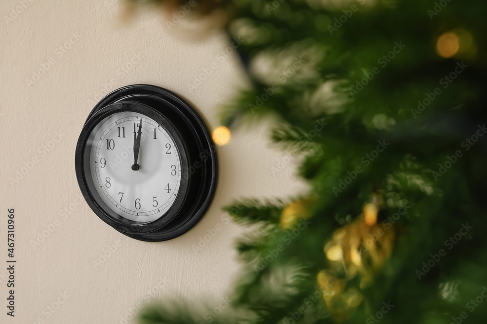 Christmas tree and black clock on wall
