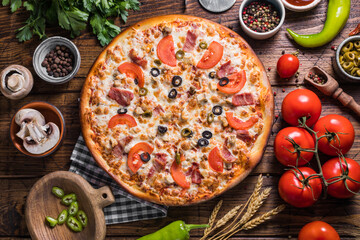 Wall Mural - Homemade pizza with jalapeno peppers on a wooden background.