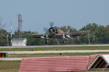 Vintage military aircraft taking off in an airbase