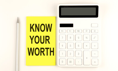 Wall Mural - text KNOW YOUR WORTH on yellow sticker, next to pen and calculator