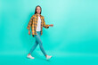© deagreez - Full size profile photo of hr mature brunette lady walk wear shirt jeans footwear isolated on turquoise background