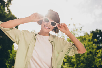 Wall Mural - Portrait of attractive cheerful carefree positive girl touching specs on fresh air sun shine bright outdoors