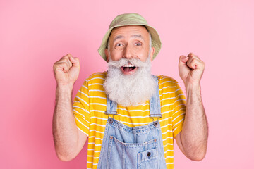 Sticker - Photo of cheerful excited crazy mature man wear sunhat raise fists in victory triumph isolated on pink color background