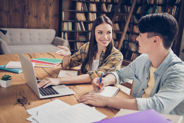 Canvas Print - Portrait of two attractive cheerful classmates learners using laptop preparing task project discussing at loft industrial interior indoors