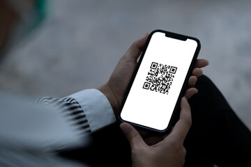 Young woman holding smartphone with QR code screen for authentication permission and online shopping.