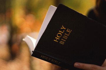 Christian teen girl holds bible in her hands. Reading the Holy Bible. Concept for faith, spirituality and religion. Peace, hope