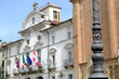 Asti town all. Asti town hall. Ancient Italian white palace with balcony and flags of Italy, Europe and Piedmont, waving in the wind. 