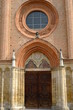 Brick rosette. Collegiate Church of San Secondo in Asti.Circular rose window and entrance portal to the church with pointed arch. Asti, Piedmont, Italy.