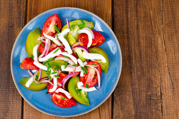 Wall Mural - Healthy vegetable salad with tomatoes and squid pieces. Studio Photo.