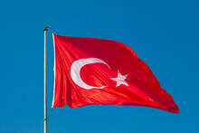 Turkish Flag Or Flag Of Turkey Waving On Flagpole Against Blue Sky In Istanbul. Space For Text