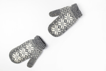 Wall Mural - Winter woolen mittens with a pattern isolated on a white background. Winter accessory. Flat lay, top view.