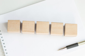 five blank wood cube dices on aged table.