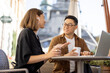 © rh2010 - Multiracial business people talking and working with laptop in cafe. Concept of remote and freelance work. Idea of teamwork and business cooperation. Caucasian woman and asian man drinking coffee