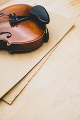 Sticker - fine acoustic violin on a brown paper and wooden background