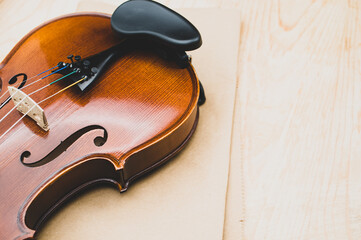 Sticker - fine acoustic violin on a brown paper and wooden background