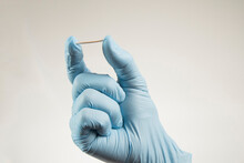 Hand In Rubber Gloves Holding A Hormonal Implant.