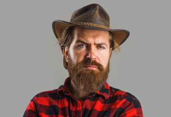 Wall Mural - Handsome man in cowboy hat. Western style portrait. Bearded macho in plaid shirt. American cowboy.