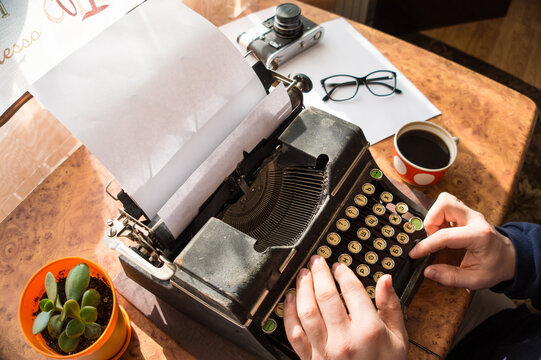 Male writer writing his book on an old antique typewriter. An old antique typewriter.