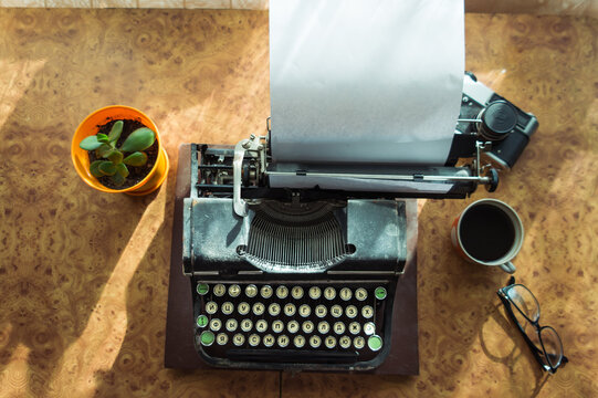 Old antique typewriter with inserted paper for writing articles and books on the desktop.