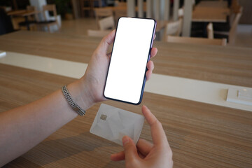 Mockup picture of business woman’s hands holding smart phone with white blank screen in modern place