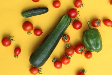 Sticker - Fresh vegetables lie on a yellow background: tomatoes, cucumbers and zucchini.