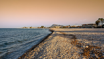 Canvas Print - Sunset view of a white pebbles Mediterranean  beach in Denia, Spain.