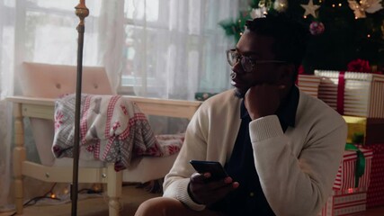 Worried black man during Christmastime at home