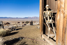 Skeleton Leaning Against A Wall In A Ghost Town In The Desert