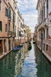 Fototapeta Miasto - Venice, Italy - 10.12.2021: Traditional canal street with gondolas and boats in Venice, Italy.