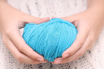 Poster - blue ball of wool in hands on the background of a white knitted tablecloth