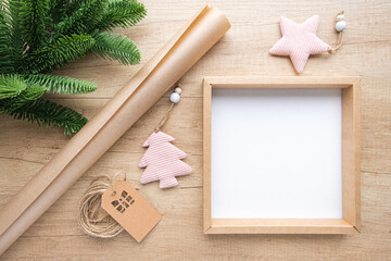  Empty gift box with copy space, roll of kraft paper, Christmas decorations and fir branch on a wooden background. Eco packaging concept, zero waste. Gift wrapping for the holidays, New Year's decor.