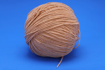 Wall Mural - brown woolen ball on blue background