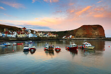 Moored Boats In A Harbour At Sunrise, Staithes, North Yorkshire, England, UK.
