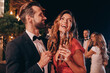 © gstockstudio - Beautiful young couple in formalwear toasting with champagne while spending time on luxury party