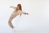 Fototapeta Nowy Jork - Girl dancing and laughing in a beige suit