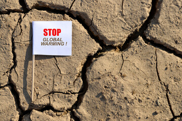 Wall Mural - Stop Global Warming banner on arid cracked soil. Concept of climate change.