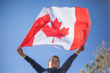 Kid boy holding Canada flag. Canadian National Holiday. 1 July.