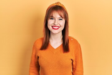 Wall Mural - Redhead young woman wearing casual orange sweater with a happy and cool smile on face. lucky person.