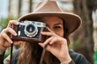 © Krakenimages.com - Young hispanic tourist woman smiling happy using vintage camera at the city.