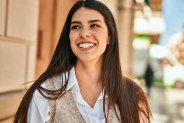 Young hispanic woman smiling happy standing at the city.