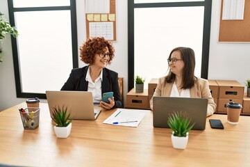 Wall Mural - Group of two women working at the office. Mature woman and down syndrome girl working at inclusive teamwork.