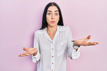 Canvas Print - Beautiful woman with blue eyes wearing casual white shirt clueless and confused expression with arms and hands raised. doubt concept.