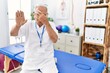 © Krakenimages.com - Senior physiotherapy man working at pain recovery clinic covering eyes with hands and doing stop gesture with sad and fear expression. embarrassed and negative concept.