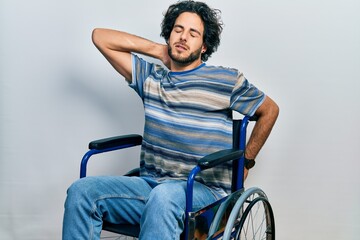 Sticker - Handsome hispanic man sitting on wheelchair suffering of neck ache injury, touching neck with hand, muscular pain